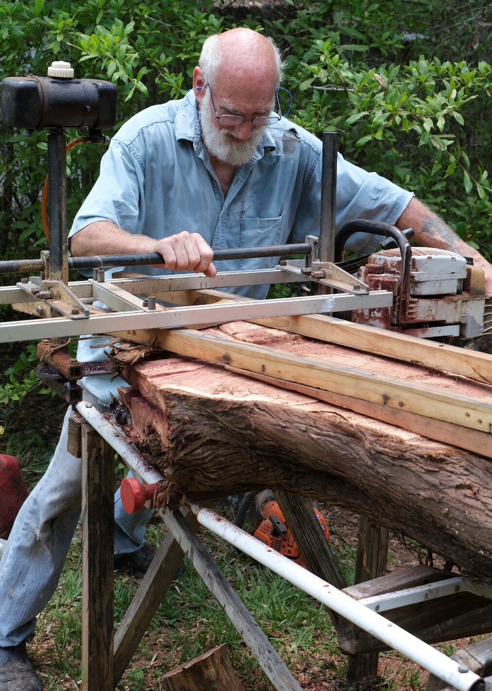 Jim Rivers slices a cedar log into planks.